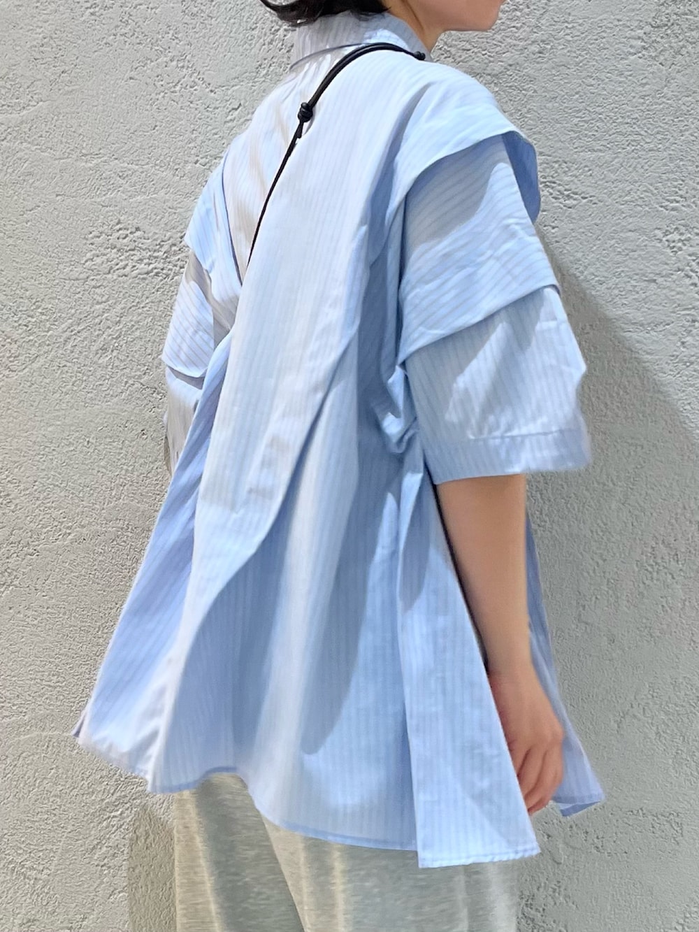ブラック系のサンダル、グレー系のその他パンツ、ブルー系のシャツ/ブラウスを着用したレディースの夏コーディネートの4枚目の写真