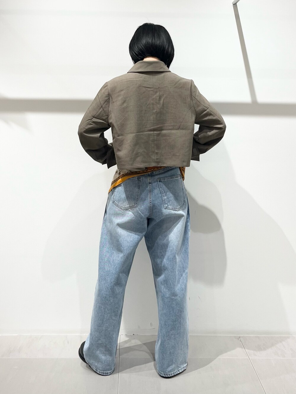 ブルー系のデニムパンツ、ブラック系のその他シューズ、ベージュ系のその他アウターを着用したレディースの秋コーディネートの3枚目の写真