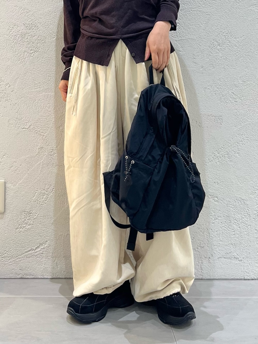 ベージュ系のその他パンツ、ブラウン系のカーディガン/ボレロ、ブラック系のバックパック/リュックを着用したレディースの秋コーディネートの8枚目の写真