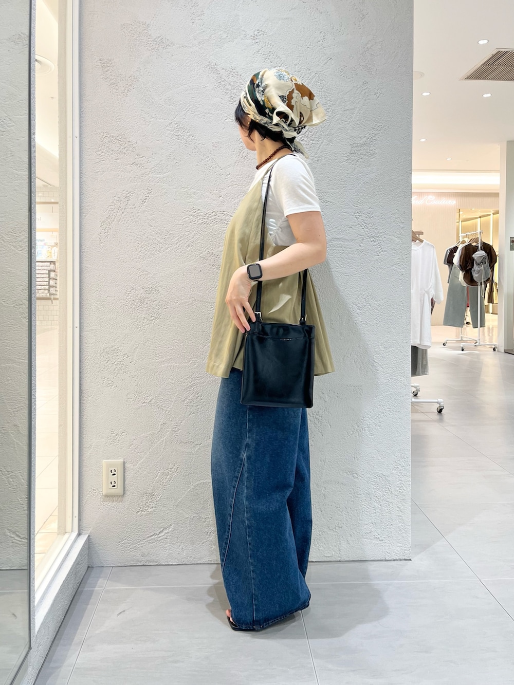 ブラック系のサンダル、ホワイト系のTシャツ/カットソー、ブルー系のデニムパンツを着用したレディースの夏コーディネートの2枚目の写真