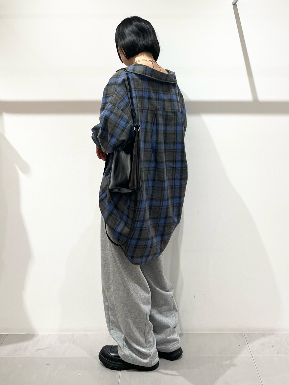 ブルー系のシャツ/ブラウス、ブラック系のショルダーバッグ、ブラック系のブーツを着用したレディースの秋コーディネートの3枚目の写真