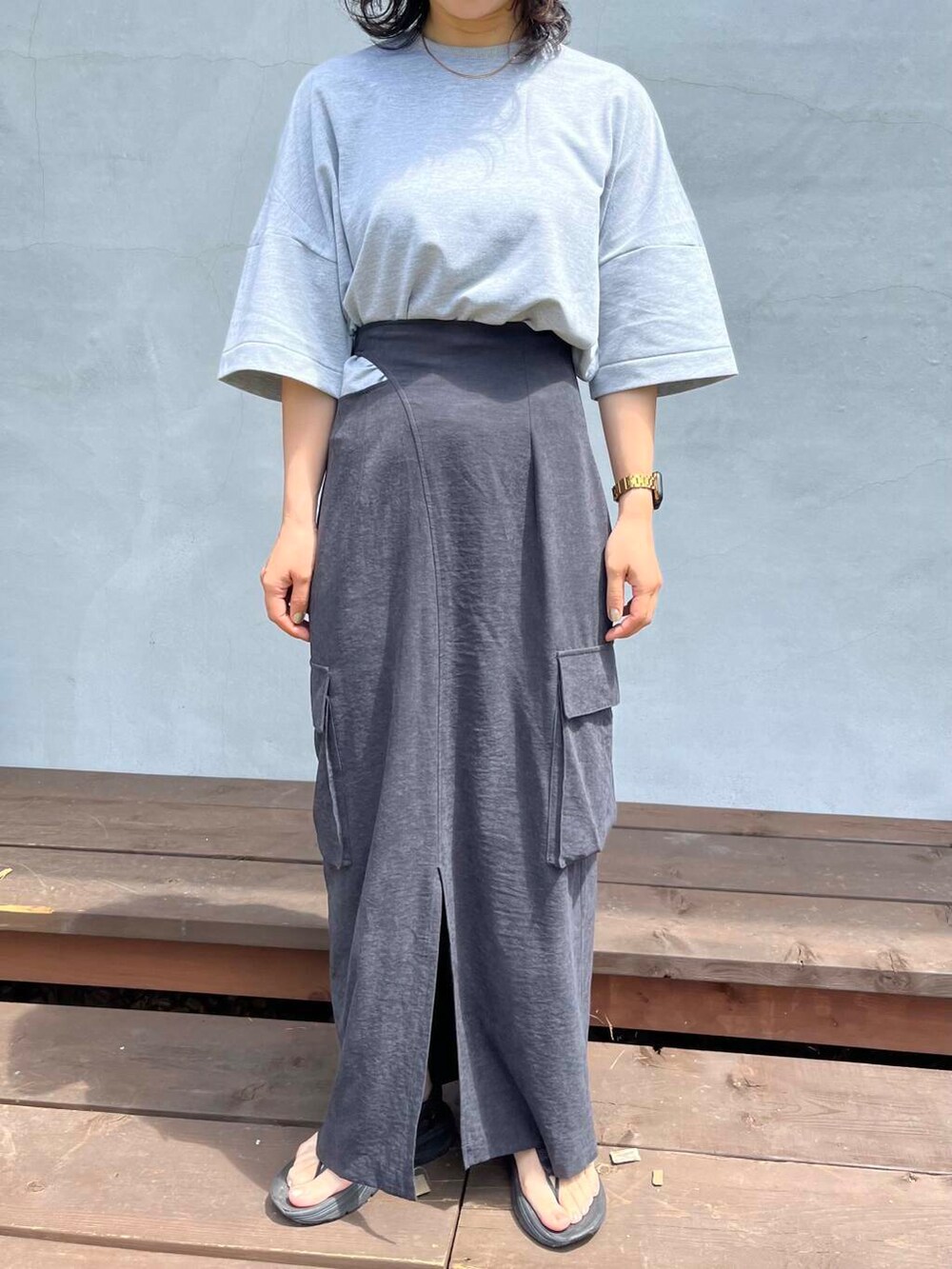 グレー系のTシャツ/カットソー、ブラック系のサンダルを着用したレディースの夏コーディネートの5枚目の写真