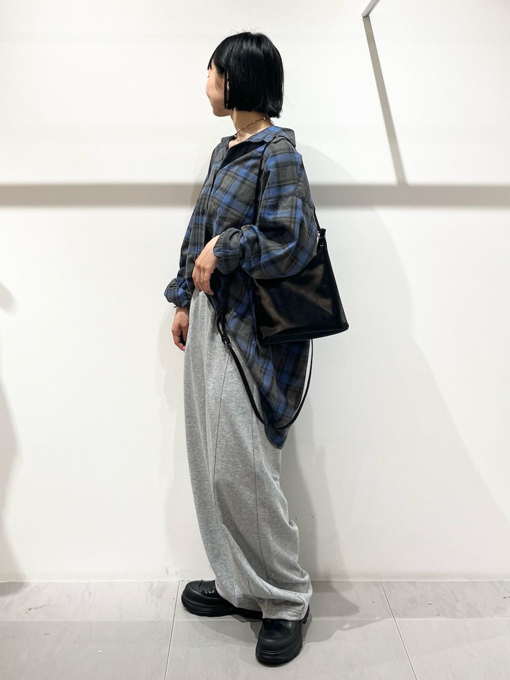 ブルー系のシャツ/ブラウス、ブラック系のショルダーバッグ、ブラック系のブーツを着用したレディースの秋コーディネートの4枚目の写真