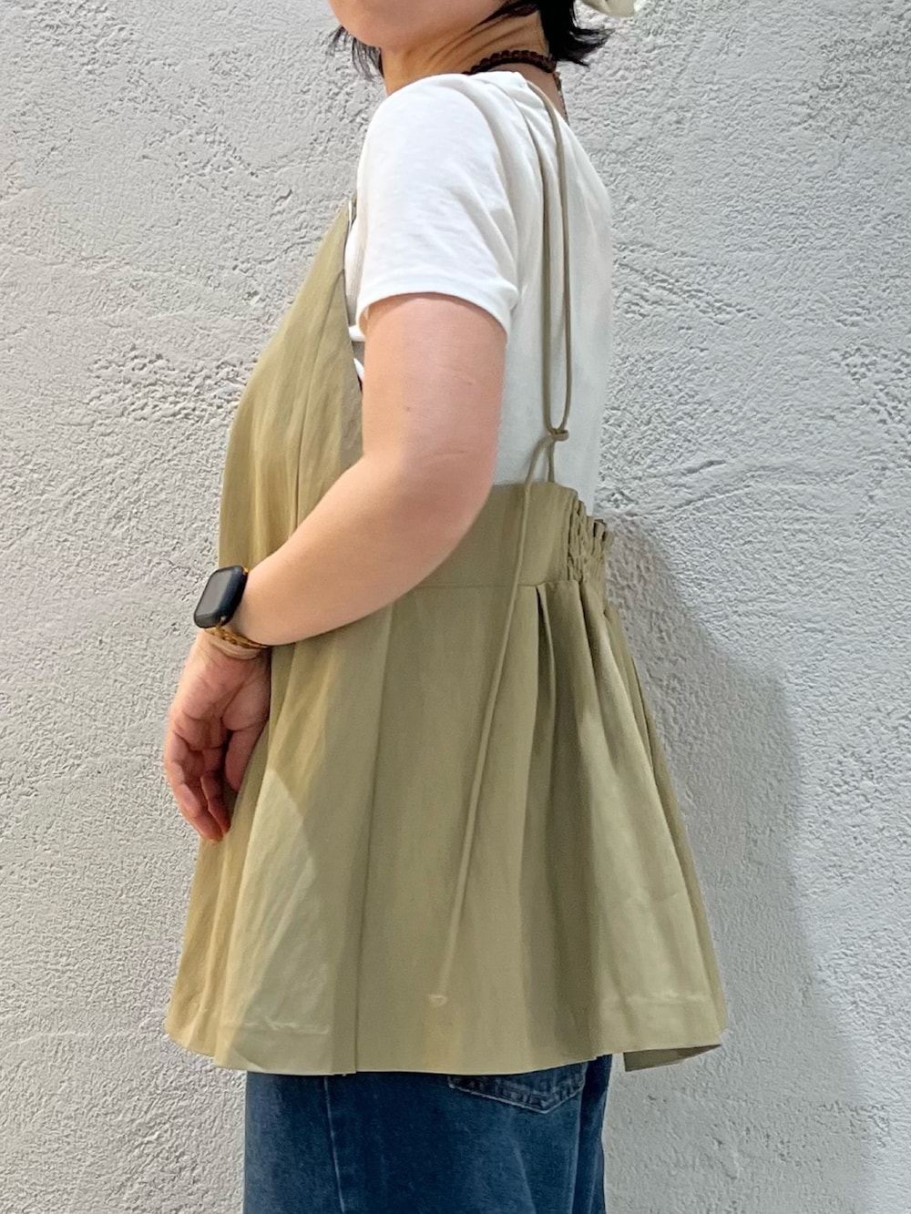 ブラック系のサンダル、ホワイト系のTシャツ/カットソー、ブルー系のデニムパンツを着用したレディースの夏コーディネートの5枚目の写真