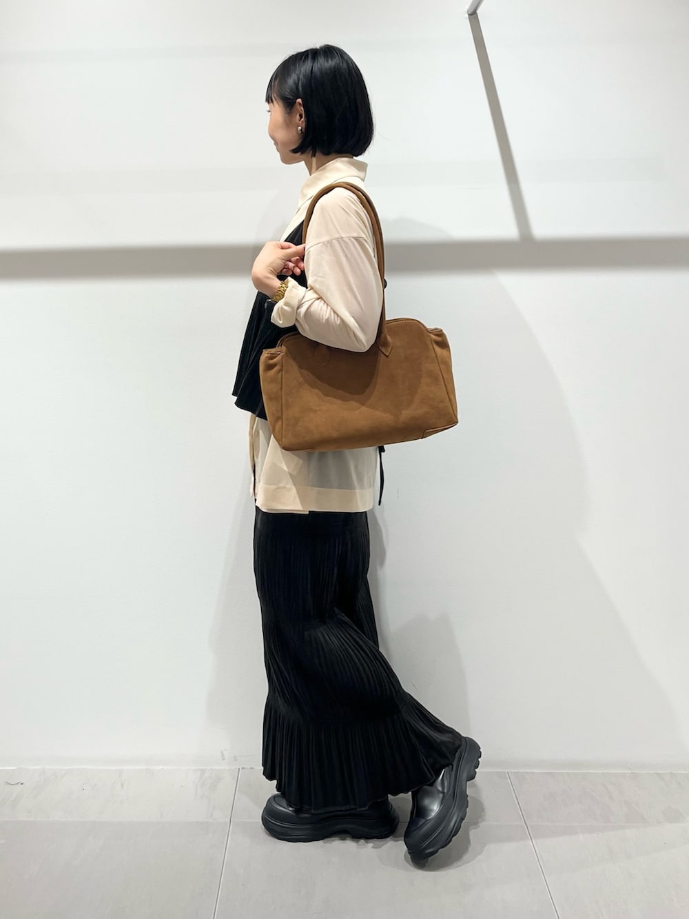 ブラック系のブーツ、ブラウン系のワンピース、ベージュ系のシャツ/ブラウスを着用したレディースの秋コーディネートの4枚目の写真