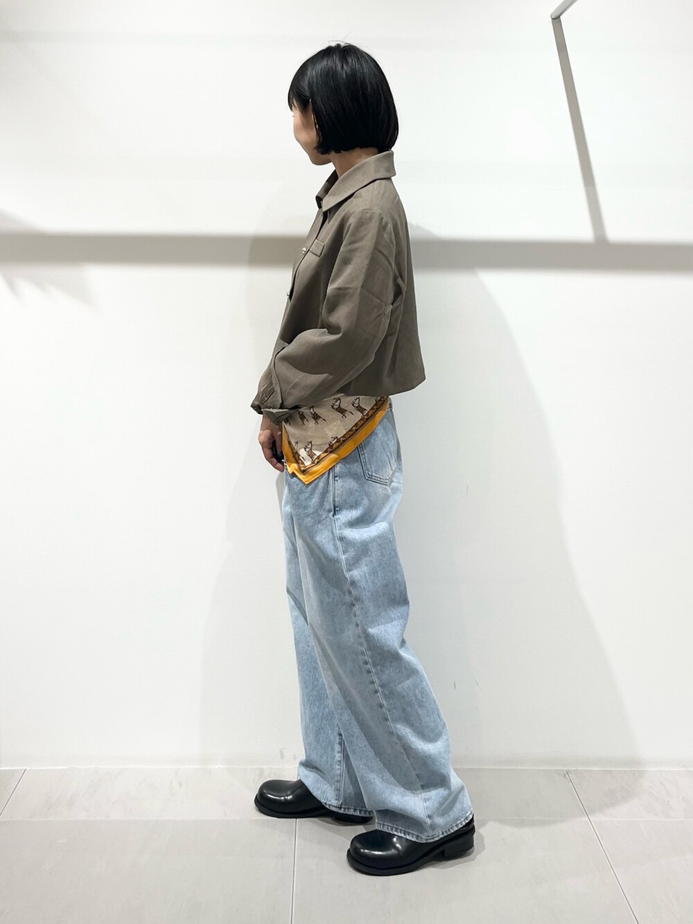 ブルー系のデニムパンツ、ブラック系のその他シューズ、ベージュ系のその他アウターを着用したレディースの秋コーディネートの2枚目の写真