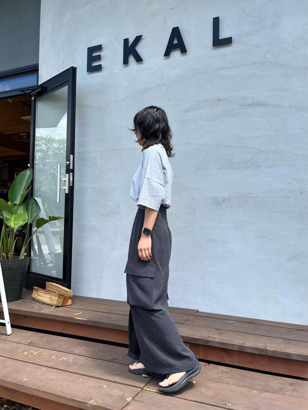 グレー系のTシャツ/カットソー、ブラック系のサンダルを着用したレディースの夏コーディネートの2枚目の写真