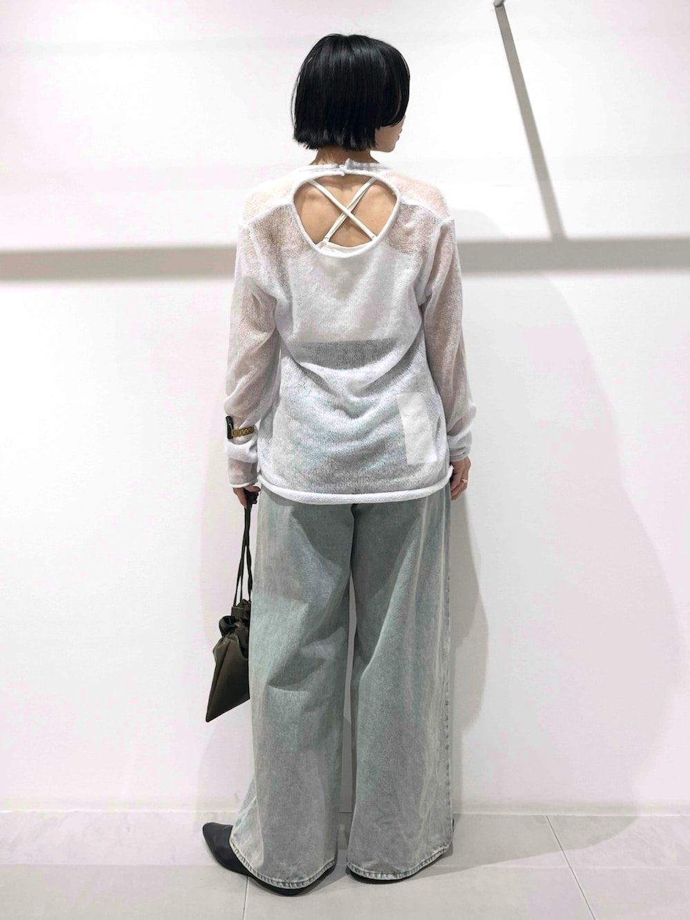 ブラック系のその他シューズ、グリーン系のショルダーバッグ、ブルー系のデニムパンツを着用したレディースの冬コーディネートの3枚目の写真