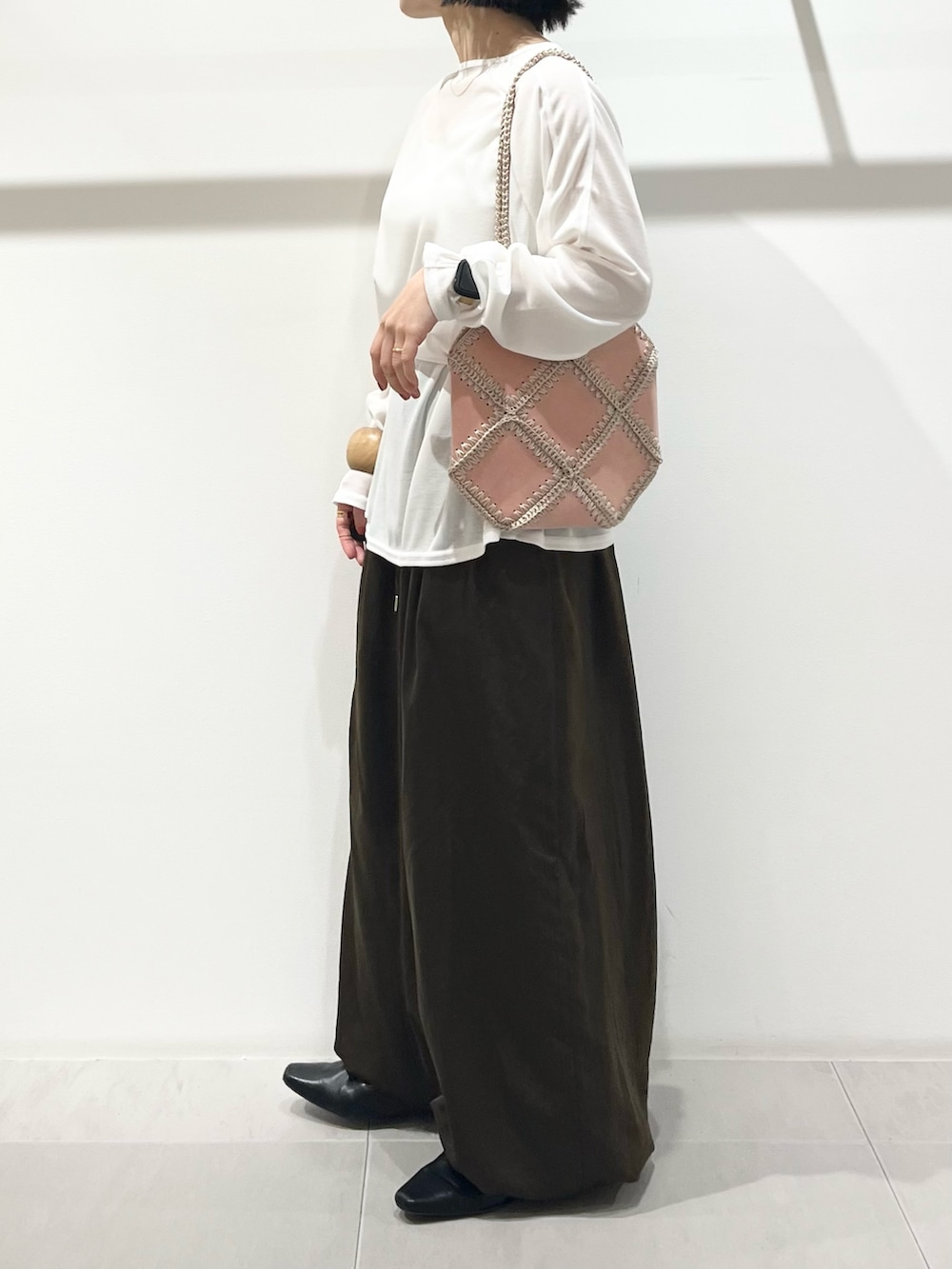 ホワイト系のTシャツ/カットソー、グリーン系のその他パンツ、ブラック系のその他シューズを着用したレディースの冬コーディネートの5枚目の写真