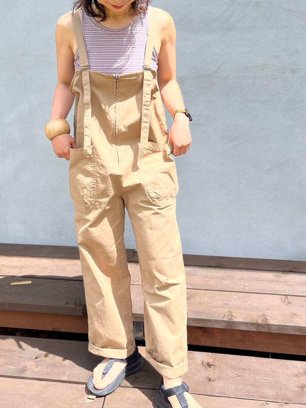 イエロー系のサロペット/オーバーオール、ブラック系のサンダルを着用したレディースの夏コーディネートの4枚目の写真