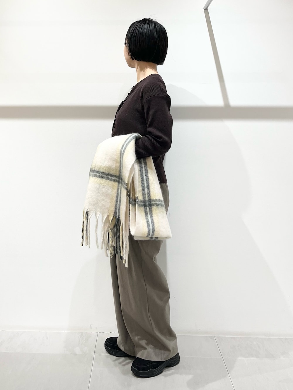 ブラウン系のニット/セーター、グレー系のその他パンツ、ブラック系のその他シューズを着用したレディースの冬コーディネートの2枚目の写真