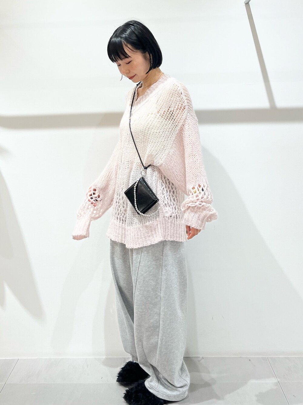 ピンク系のニット/セーター、グレー系のその他パンツ、ブラック系のその他シューズを着用したレディースの秋コーディネートの3枚目の写真