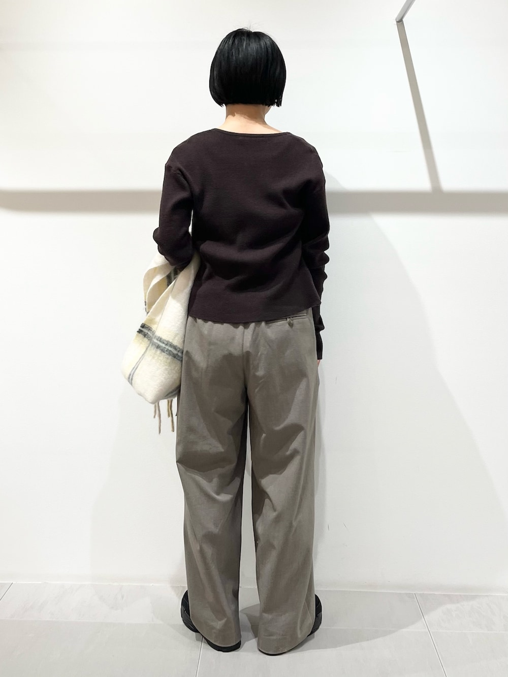 ブラウン系のニット/セーター、グレー系のその他パンツ、ブラック系のその他シューズを着用したレディースの冬コーディネートの3枚目の写真