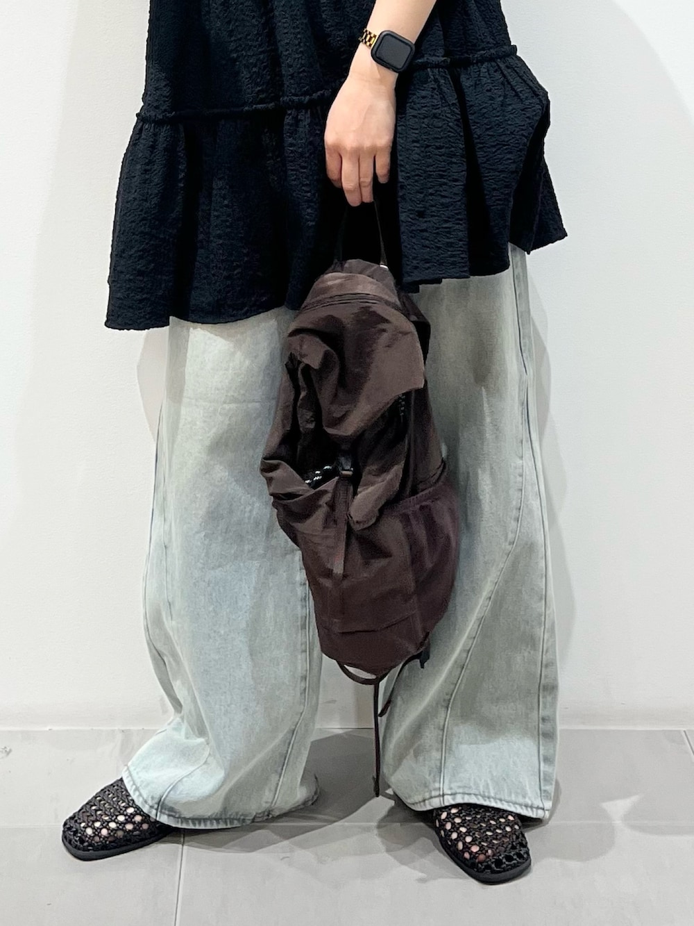 ブラウン系のバックパック/リュック、ブラック系のサンダル、ブルー系のデニムパンツを着用したレディースの春コーディネートの4枚目の写真