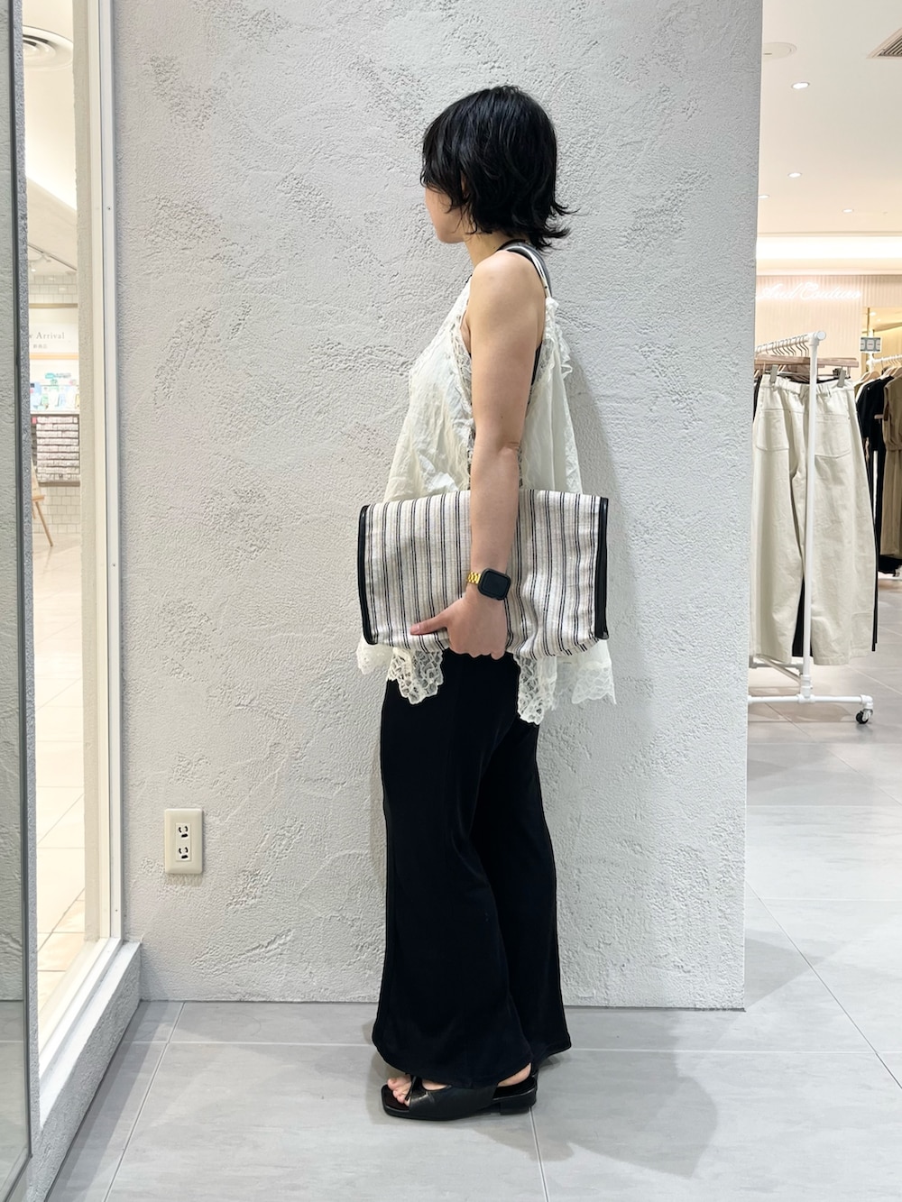 ブラック系のサンダル、ブラック系のその他パンツ、ブラック系のトートバッグを着用したレディースの夏コーディネートの2枚目の写真