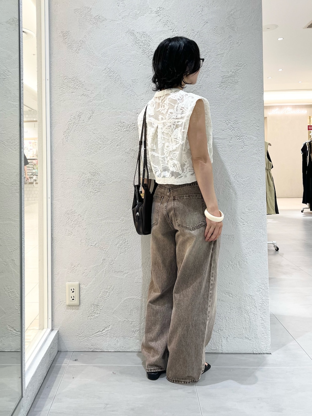 ブラウン系のショルダーバッグ、ホワイト系のシャツ/ブラウス、ブラウン系のデニムパンツを着用したレディースの夏コーディネートの4枚目の写真