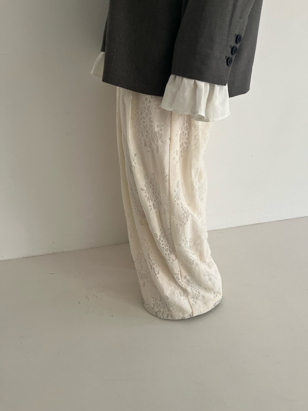 ブラック系のパンプス、グレー系のその他アウター、ホワイト系のその他パンツを着用したレディースの冬コーディネートの6枚目の写真