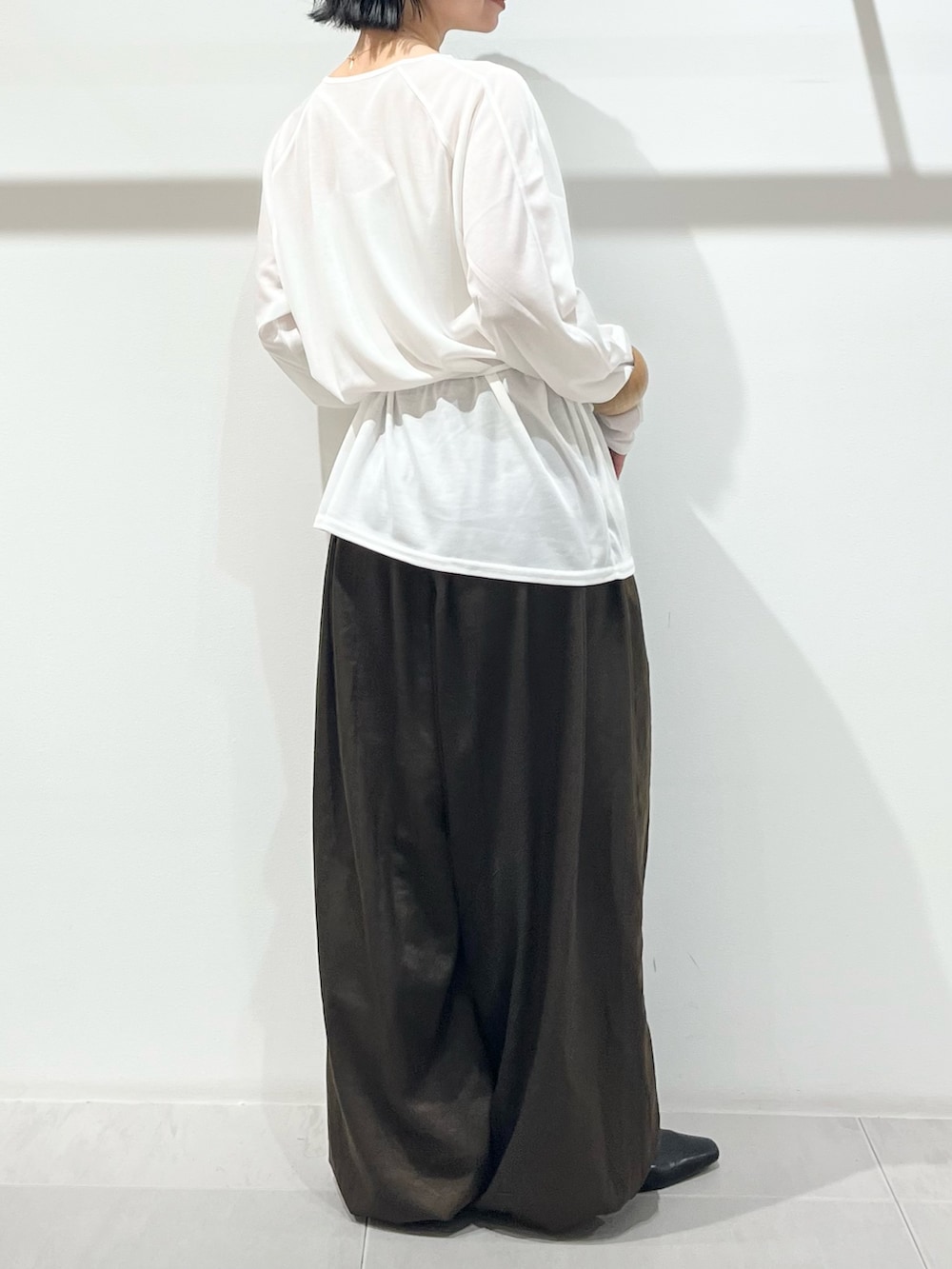 ホワイト系のTシャツ/カットソー、グリーン系のその他パンツ、ブラック系のその他シューズを着用したレディースの冬コーディネートの3枚目の写真