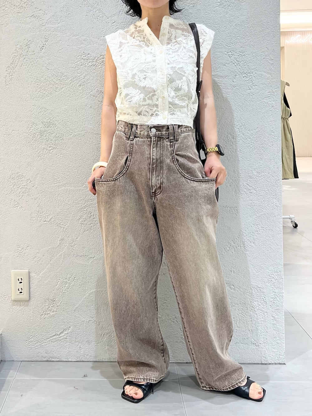 ブラウン系のショルダーバッグ、ホワイト系のシャツ/ブラウス、ブラウン系のデニムパンツを着用したレディースの夏コーディネートの9枚目の写真