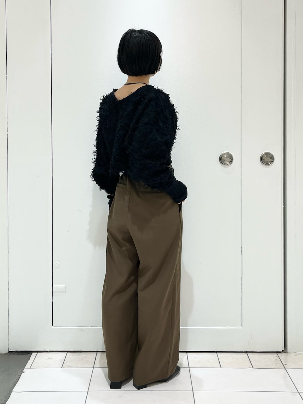 ブラウン系のその他パンツ、ブラック系のパンプス、ブラック系のカーディガン/ボレロを着用したレディースの冬コーディネートの2枚目の写真