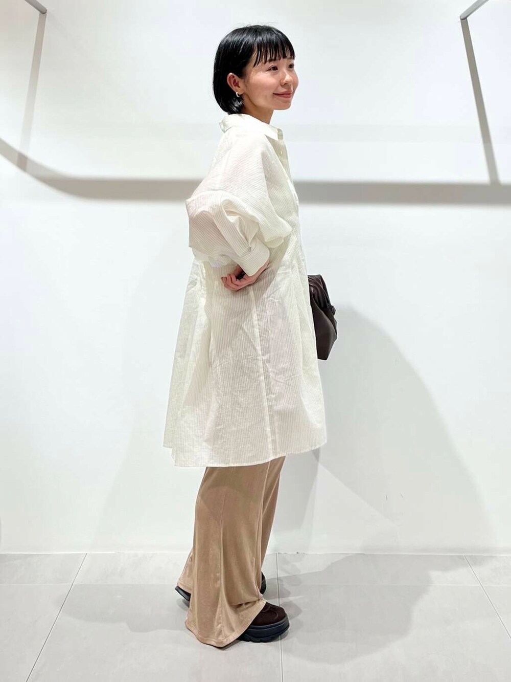 ベージュ系のその他パンツ、ホワイト系のワンピース、ブラウン系のスニーカーを着用したレディースの夏コーディネートの2枚目の写真