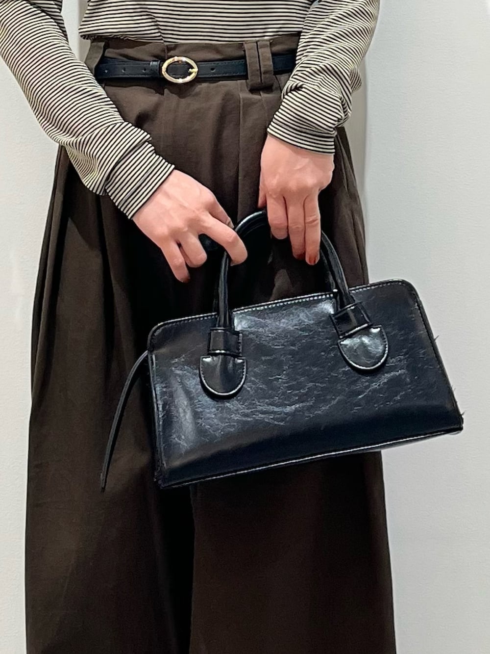 ベージュ系のキャミソール、ブラウン系のその他パンツ、ブラック系のボストンバッグを着用したレディースの春コーディネートの6枚目の写真