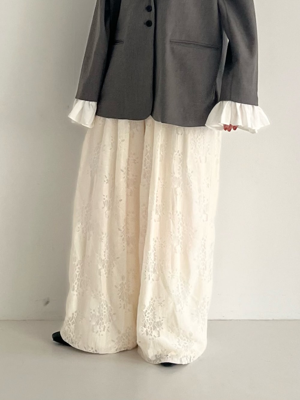 ブラック系のパンプス、グレー系のその他アウター、ホワイト系のその他パンツを着用したレディースの冬コーディネートの4枚目の写真