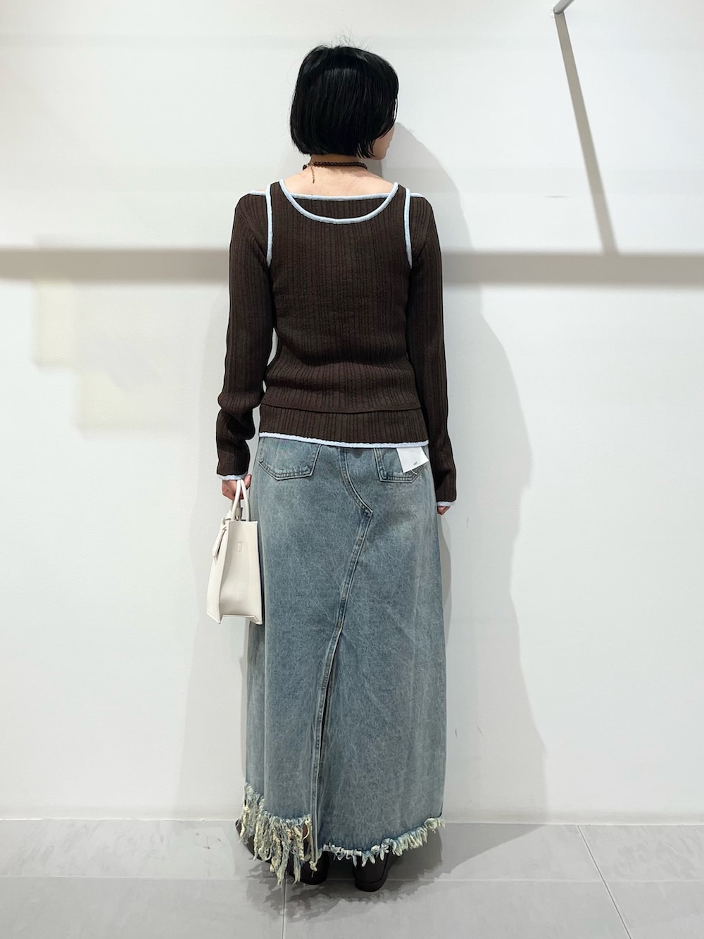 ブラウン系のその他シューズ、ブルー系のスカート、ホワイト系のハンドバッグを着用したレディースの春コーディネートの3枚目の写真