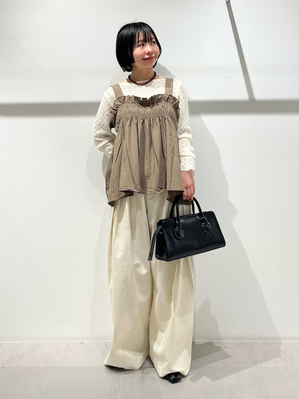 グリーン系のその他トップス、ブラック系のその他シューズ、ホワイト系のその他パンツを着用したレディースの春コーディネートの6枚目の写真