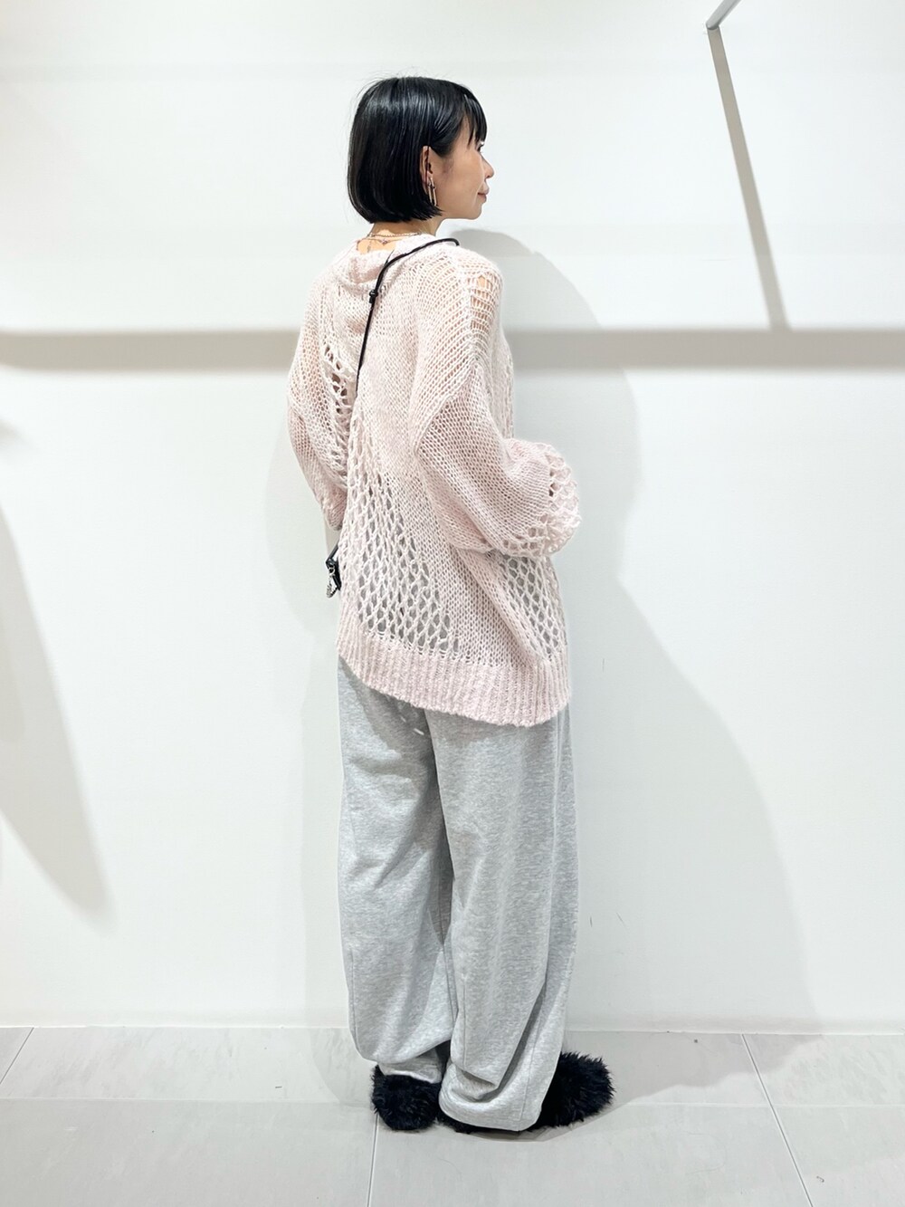 ピンク系のニット/セーター、グレー系のその他パンツ、ブラック系のその他シューズを着用したレディースの秋コーディネートの2枚目の写真