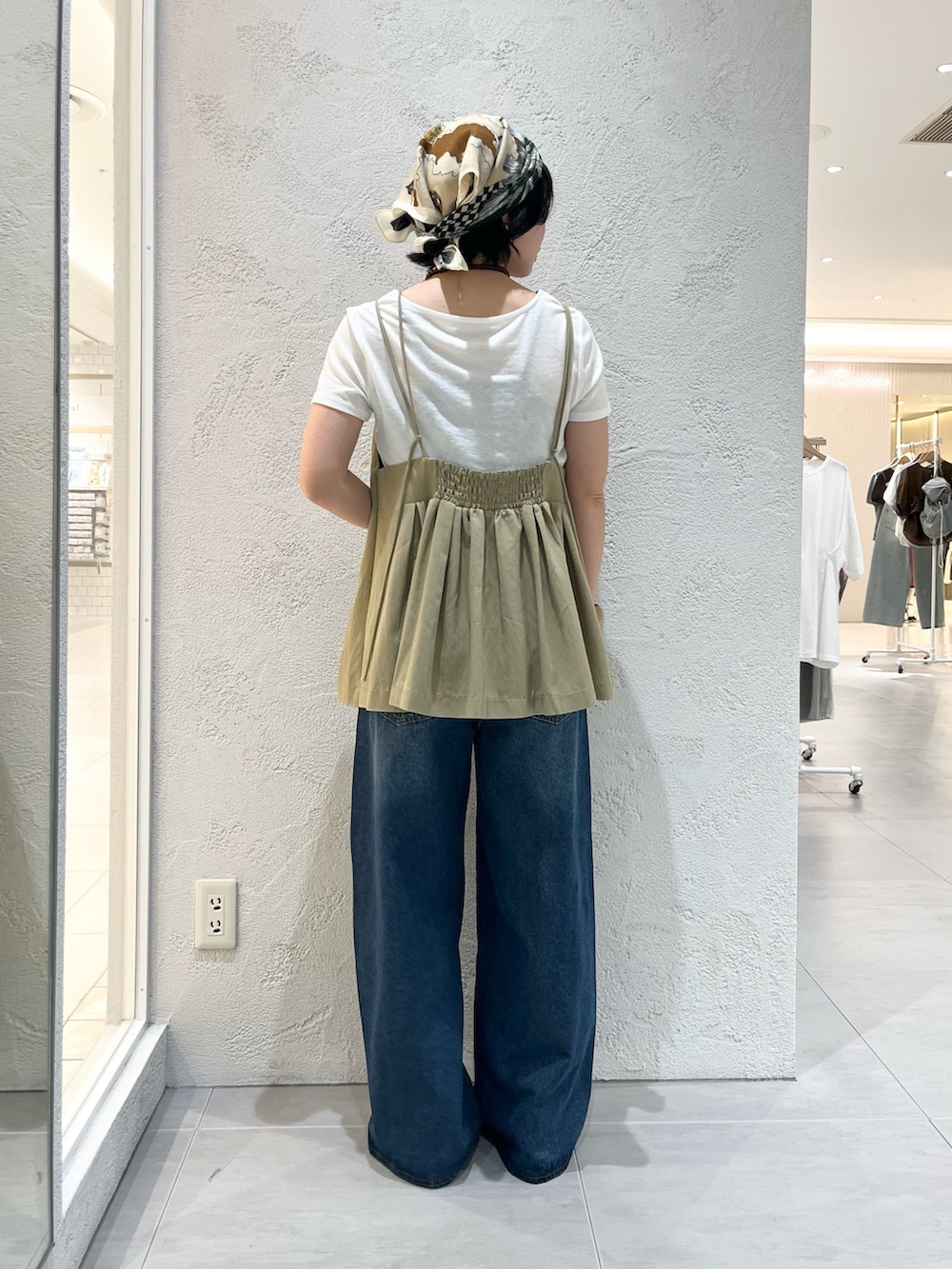ブラック系のサンダル、ホワイト系のTシャツ/カットソー、ブルー系のデニムパンツを着用したレディースの夏コーディネートの3枚目の写真