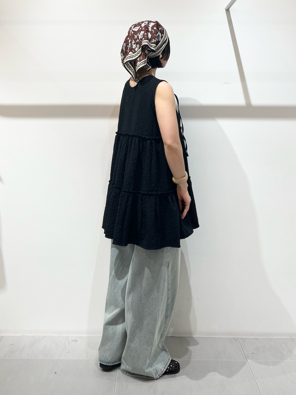 ブラウン系のバックパック/リュック、ブラック系のサンダル、ブルー系のデニムパンツを着用したレディースの春コーディネートの3枚目の写真