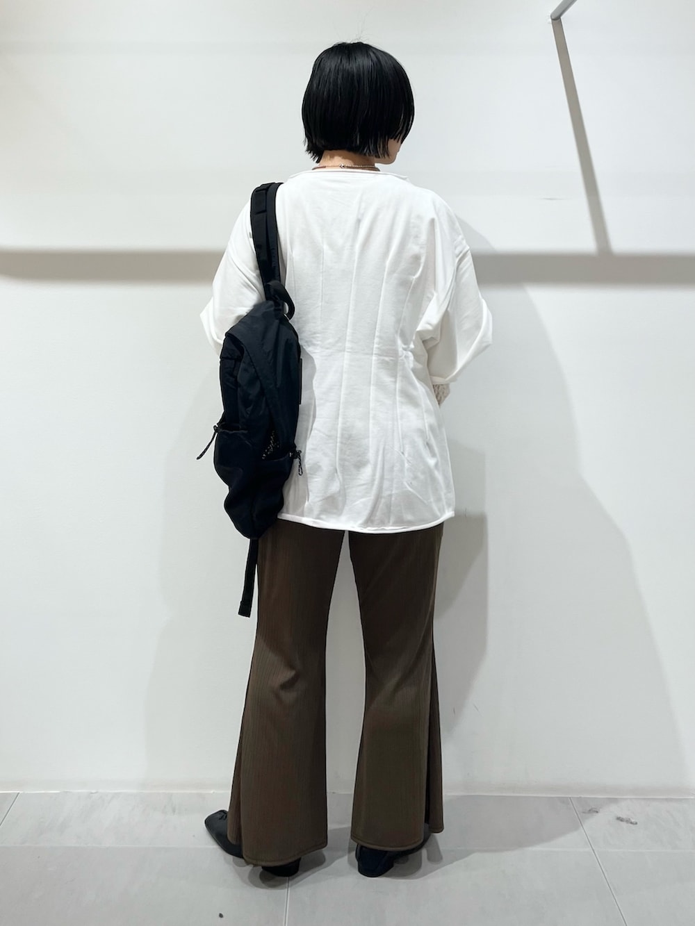 ホワイト系のTシャツ/カットソー、ブラック系のその他シューズ、ブラック系のバックパック/リュックを着用したレディースの春コーディネートの3枚目の写真