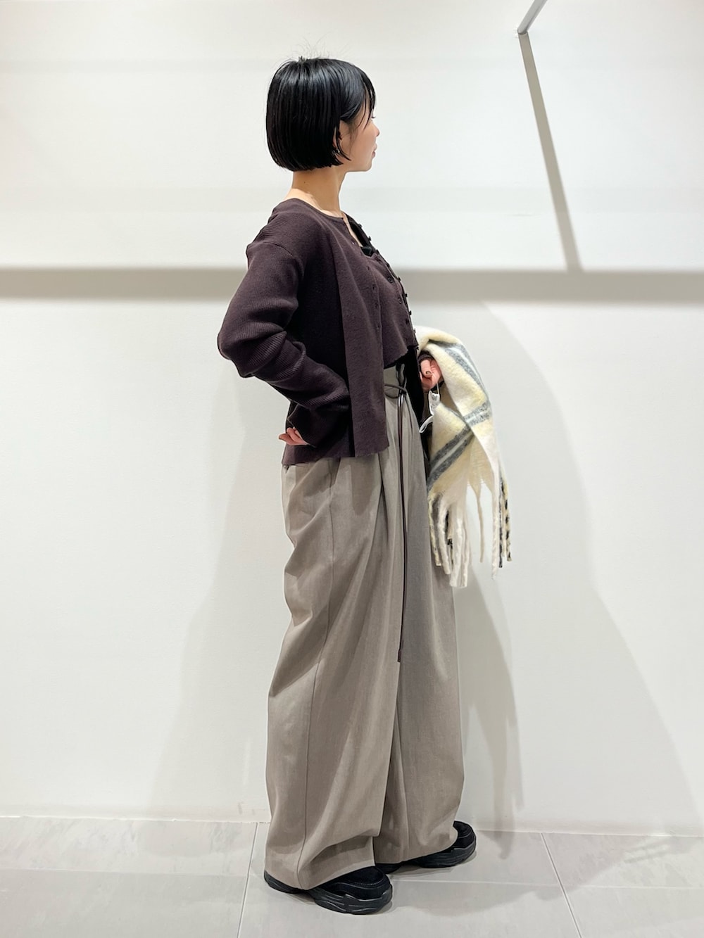 ブラウン系のニット/セーター、グレー系のその他パンツ、ブラック系のその他シューズを着用したレディースの冬コーディネートの4枚目の写真