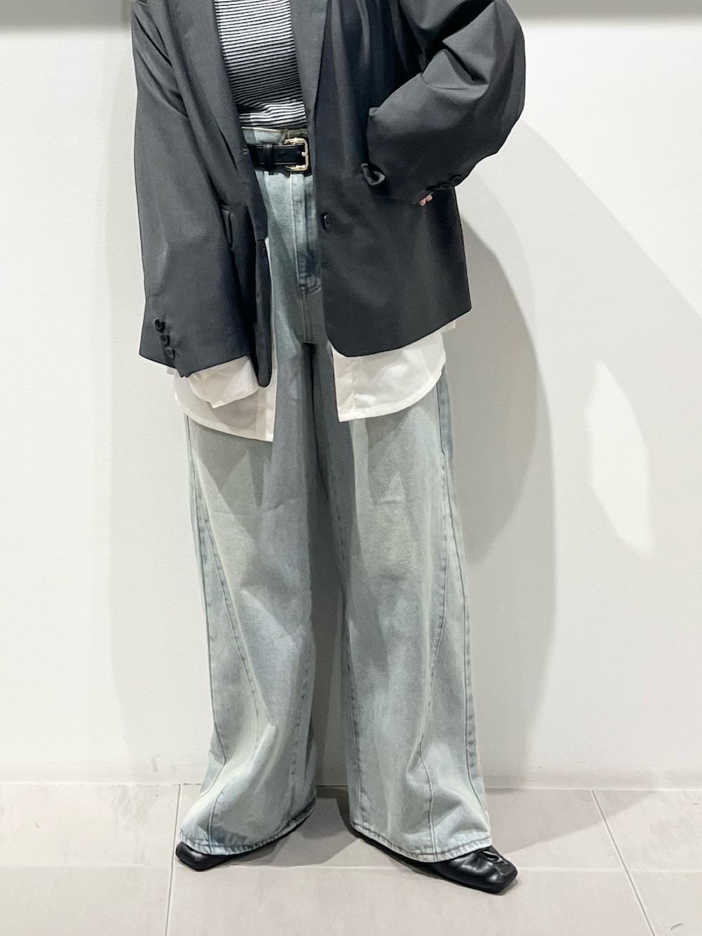 ブラック系のハンドバッグ、ブラック系のその他シューズ、ブルー系のデニムパンツを着用したレディースの春コーディネートの6枚目の写真