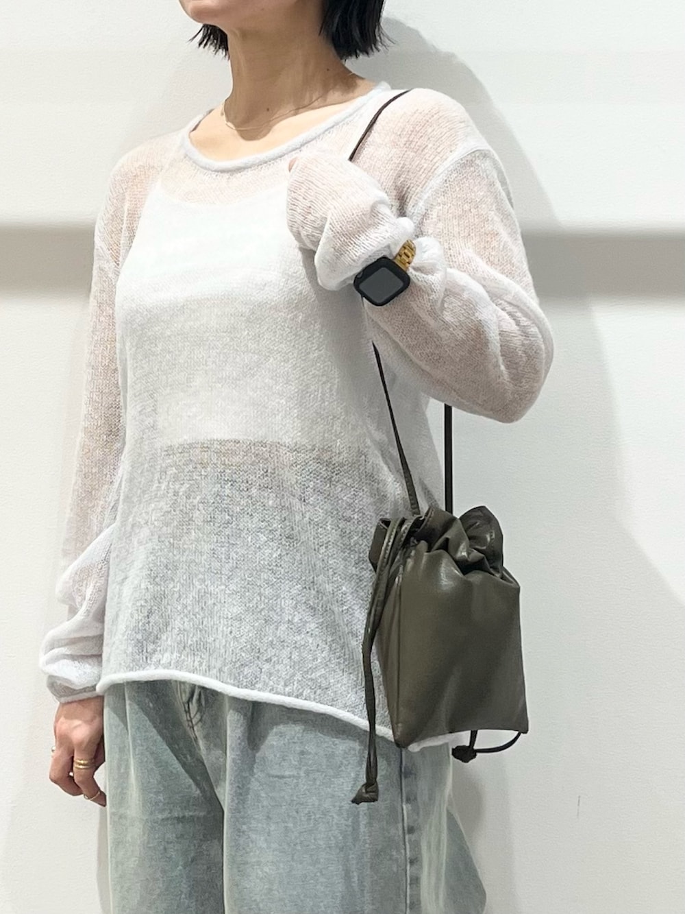 ブラック系のその他シューズ、グリーン系のショルダーバッグ、ブルー系のデニムパンツを着用したレディースの冬コーディネートの6枚目の写真