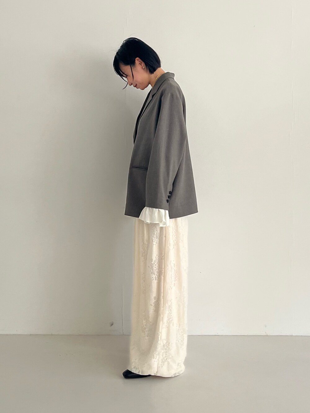 ブラック系のパンプス、グレー系のその他アウター、ホワイト系のその他パンツを着用したレディースの冬コーディネートの3枚目の写真