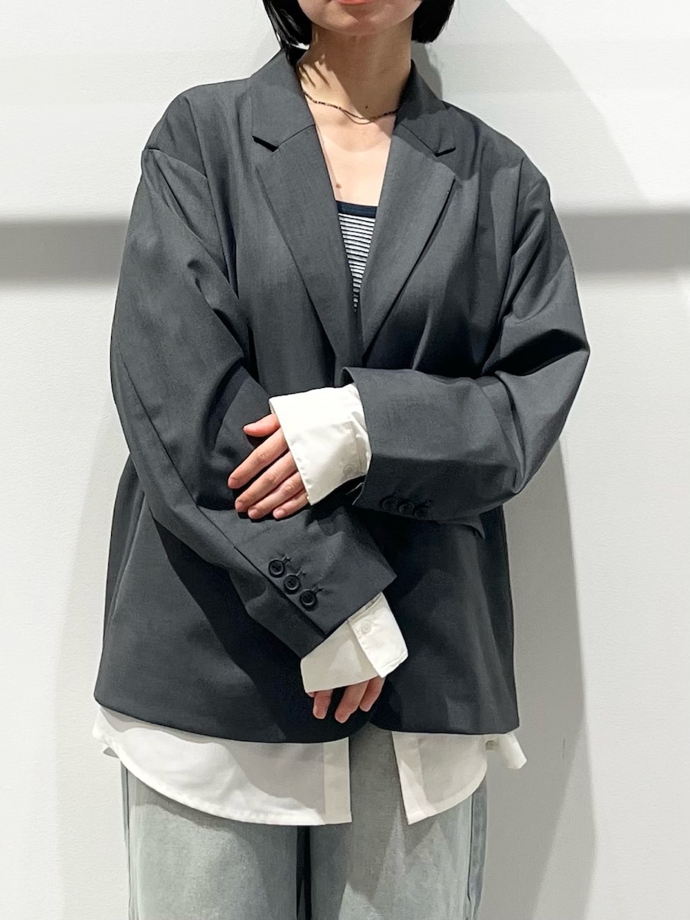 ブラック系のハンドバッグ、ブラック系のその他シューズ、ブルー系のデニムパンツを着用したレディースの春コーディネートの5枚目の写真