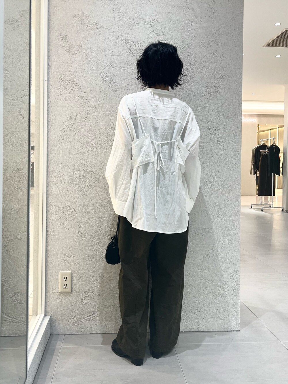 ホワイト系のシャツ/ブラウス、ブラック系のサンダル、ブラック系のショルダーバッグを着用したレディースの秋コーディネートの3枚目の写真