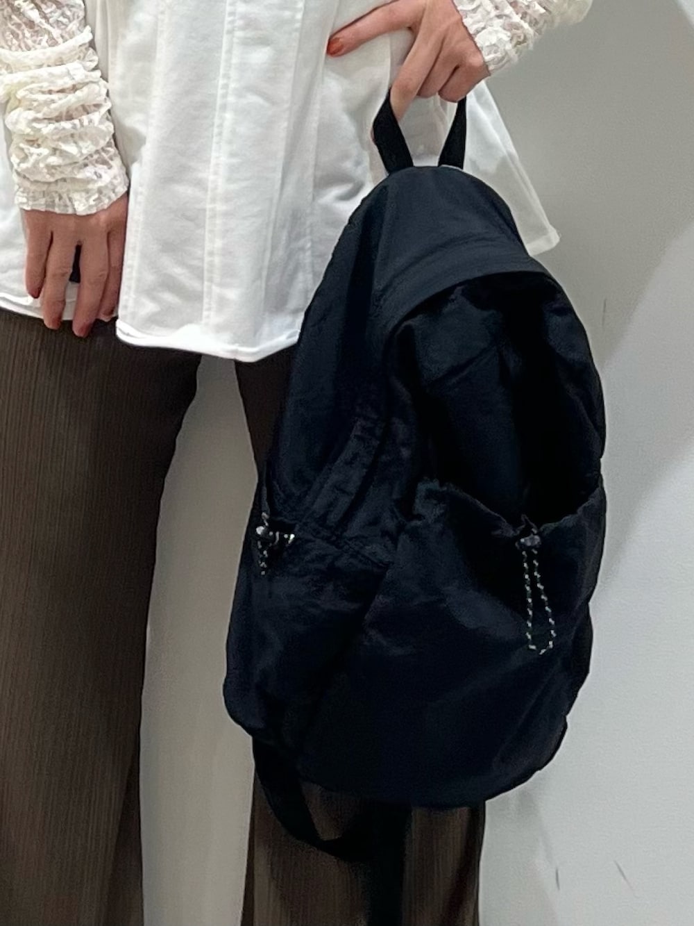 ホワイト系のTシャツ/カットソー、ブラック系のその他シューズ、ブラック系のバックパック/リュックを着用したレディースの春コーディネートの5枚目の写真