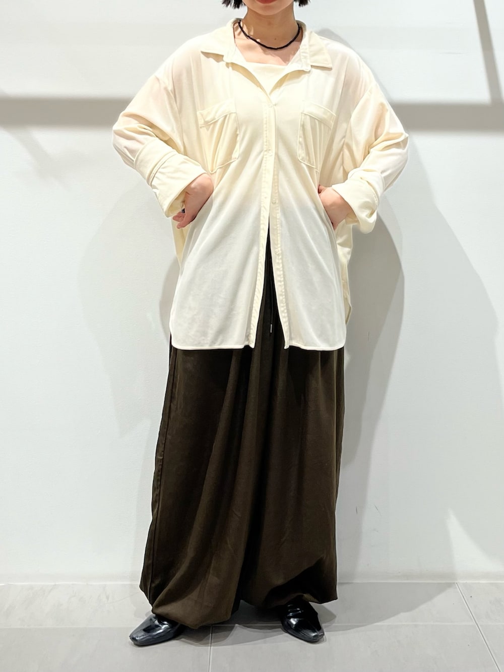 ブラック系のボストンバッグ、ホワイト系のシャツ/ブラウス、ブラック系のパンプスを着用したレディースの冬コーディネートの6枚目の写真