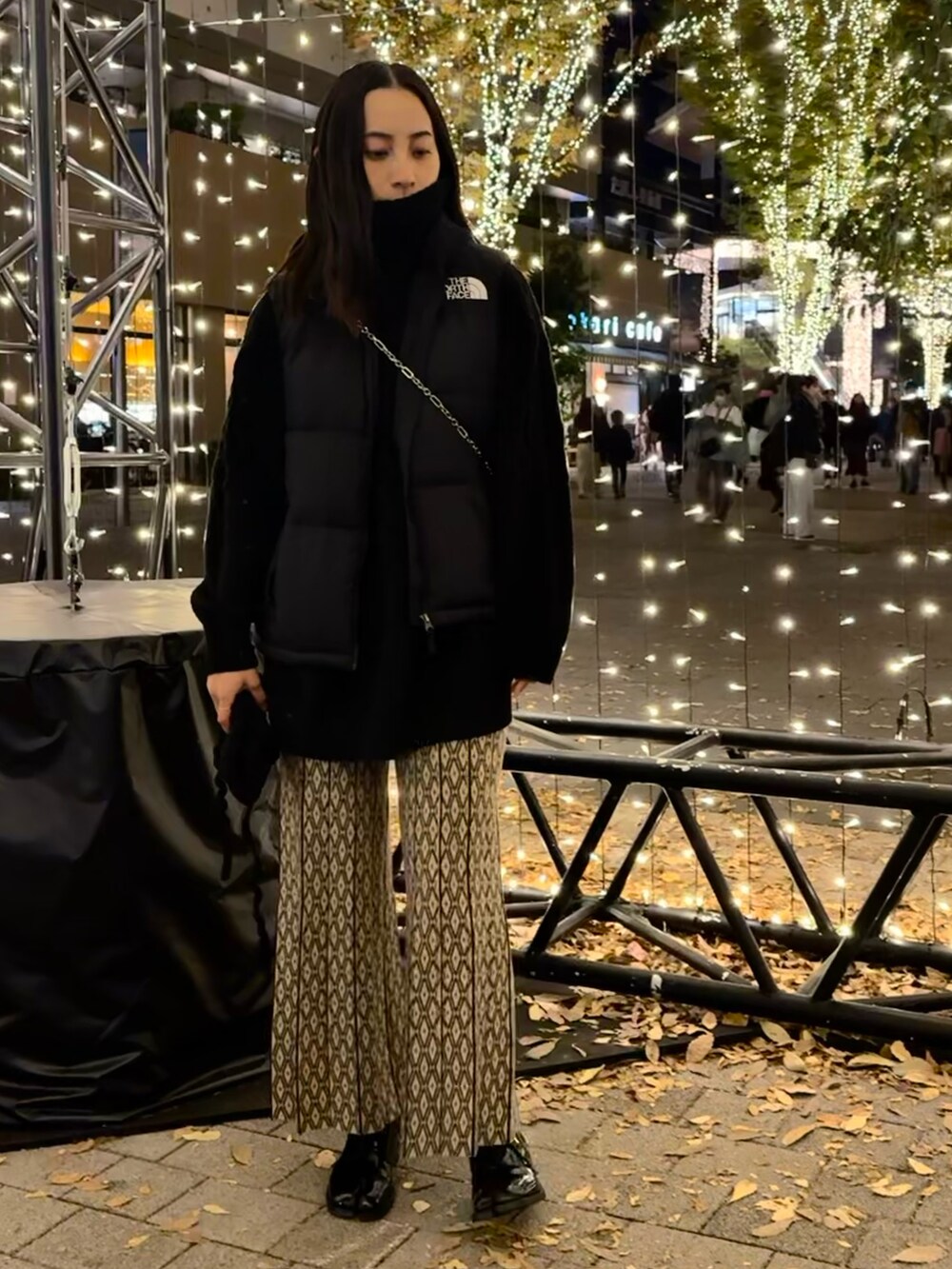 ベージュ系のその他パンツ、ブラック系のスニーカー、ブラック系のショルダーバッグを着用したレディースの秋コーディネートの2枚目の写真