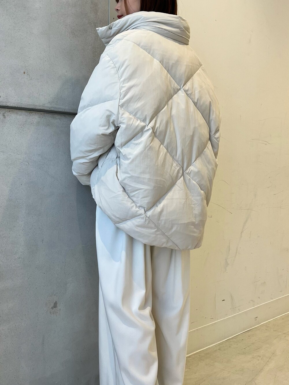 ホワイト系のダウンジャケット/コート、ブラウン系のニット/セーター、ホワイト系のその他パンツを着用したレディースの冬コーディネートの3枚目の写真