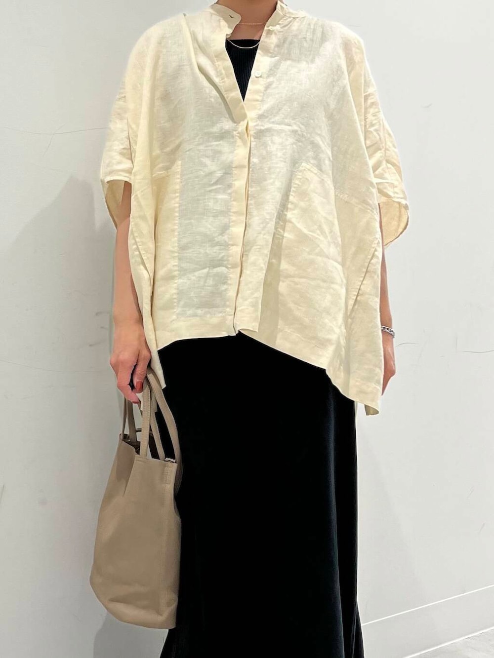 ブラック系のパンプス、ブラック系のスカート、イエロー系のシャツ/ブラウスを着用したレディースの春コーディネートの3枚目の写真