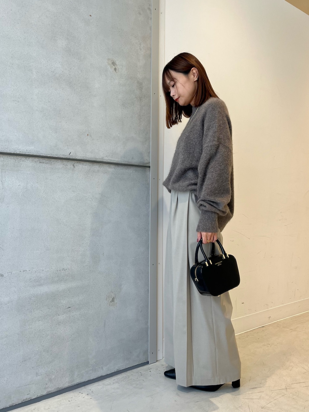 ブラウン系のニット/セーター、ベージュ系のその他パンツ、ブラック系のショルダーバッグを着用したレディースの秋コーディネートの3枚目の写真