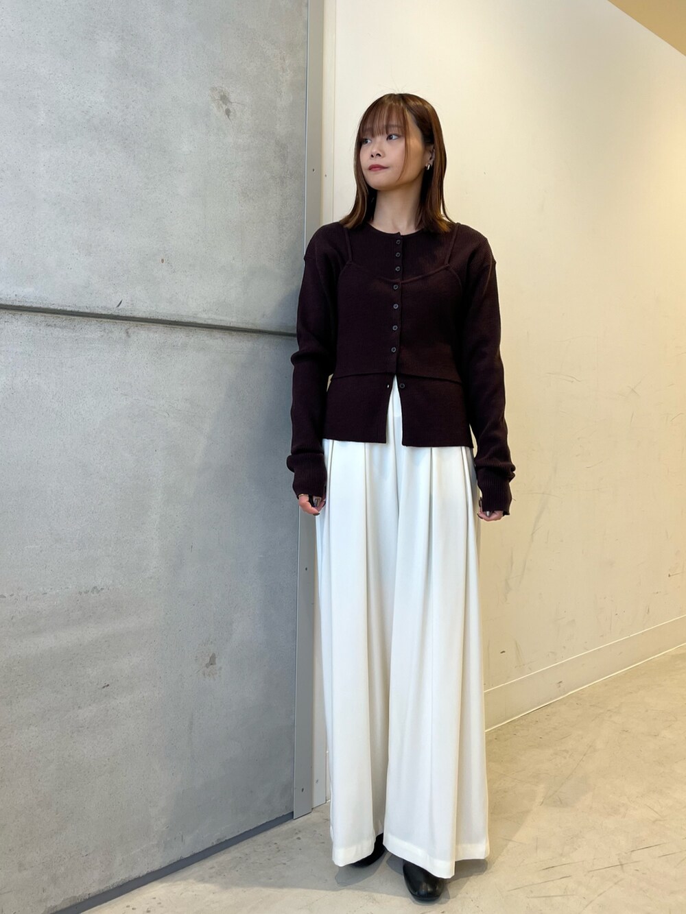 ホワイト系のダウンジャケット/コート、ブラウン系のニット/セーター、ホワイト系のその他パンツを着用したレディースの冬コーディネートの5枚目の写真