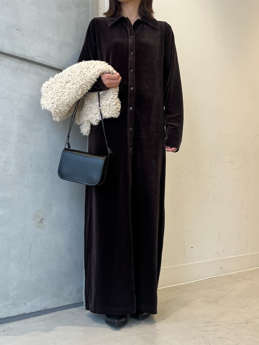 ホワイト系のベスト、ブラウン系のワンピース、ブラック系のショルダーバッグを着用したレディースの秋コーディネートの3枚目の写真