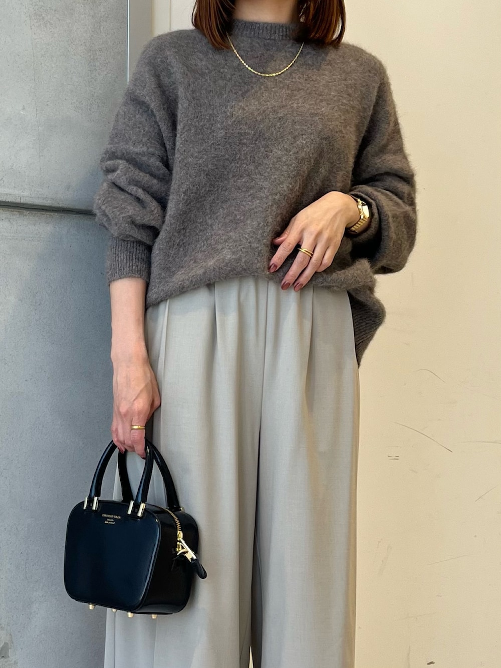 ブラウン系のニット/セーター、ベージュ系のその他パンツ、ブラック系のショルダーバッグを着用したレディースの秋コーディネートの2枚目の写真