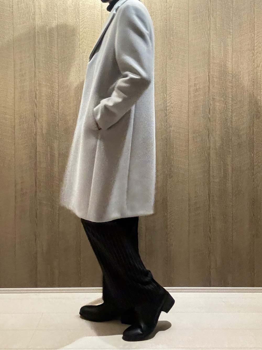 グレー系のチェスターコート、ブラック系のその他パンツ、ブラック系のブーツを着用したメンズの秋コーディネートの2枚目の写真