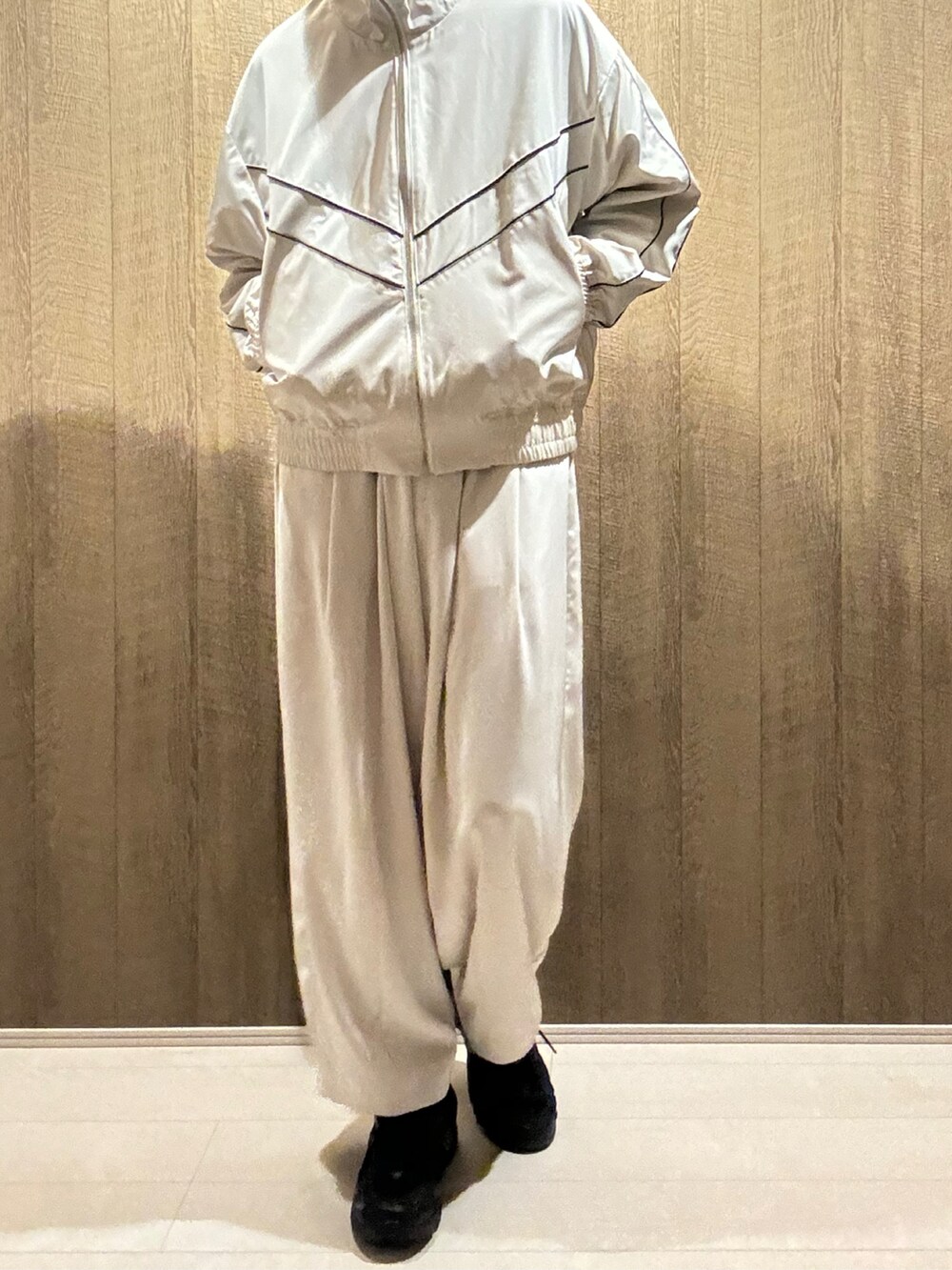 ホワイト系のブルゾン、ホワイト系のスラックス、ブラック系のスニーカーを着用したメンズの秋コーディネートの4枚目の写真